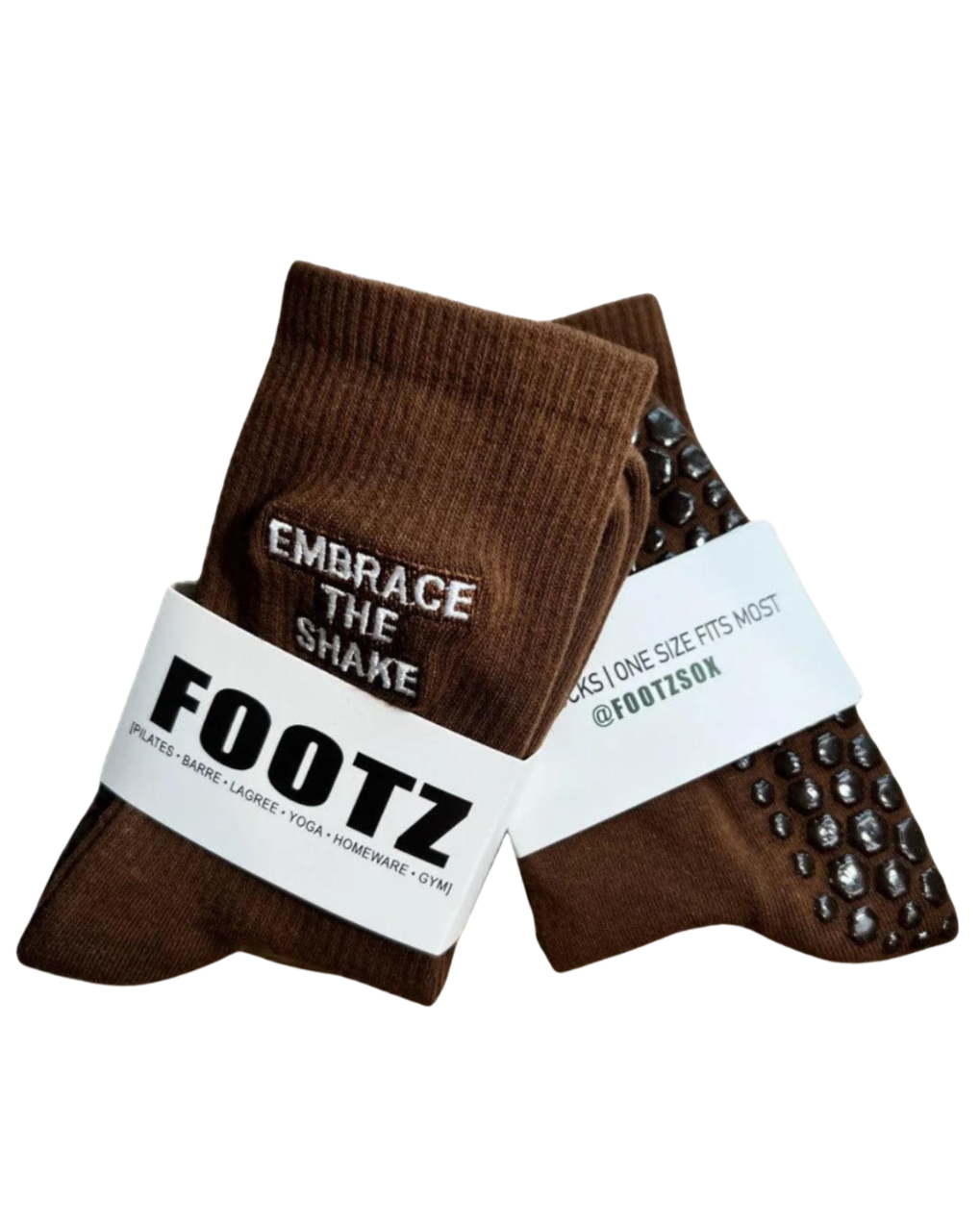 Display shows two pairs of brown Footz socks with non-slip grips, promoting pilates, barre, yoga, homeware, and gym activities, each labeled with "Embrace the Shake" and the brand's social media handle.
